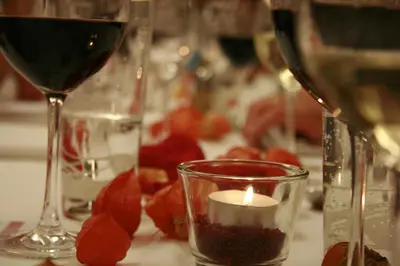 a table topped with glasses of wine and a candle at Waldgasthaus Lehmen in Weissbad