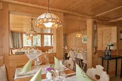 a dining room with a table and a chandelier at Hotel Alpenblick in Weissbad