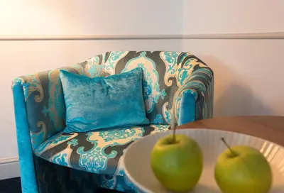 two apples on a table in front of a chair at Hotel Appenzell in Appenzell