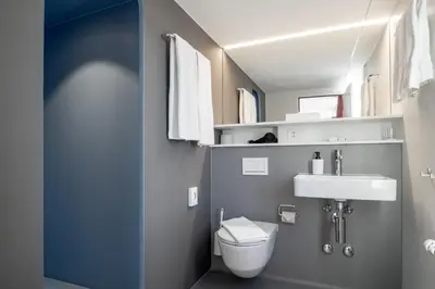 a small bathroom with a toilet and a sink at Linde Heiden Swiss Quality Hotel in Heiden