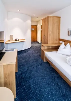 a hotel room with a bed and a desk at Hotel Rössli Tufertschwil in Lütisburg