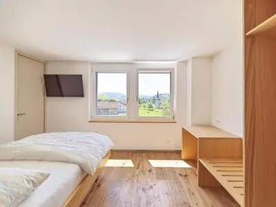 a bedroom with a bed and two windows at Hotel Rössli Tufertschwil in Lütisburg
