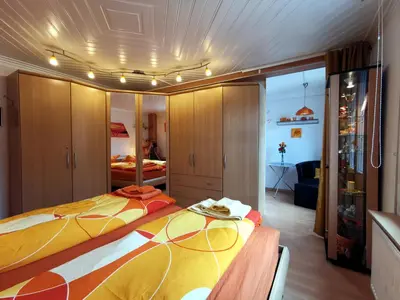 a bedroom with a large bed and a room with a bed sqor at Ferienwohnungen im Fürstenland in Gossau