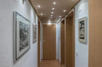 a hallway with framed pictures on the walls and a door at Ferienwohnungen im Fürstenland in Gossau