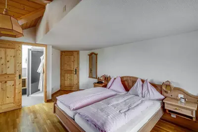 a bedroom with a large bed with pink pillows at Hotel Landgasthof Eischen in Appenzell