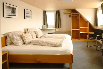 a bedroom with a bed and a staircase at Hotel Landgasthaus Neues Bild, Eggerstanden in Appenzell