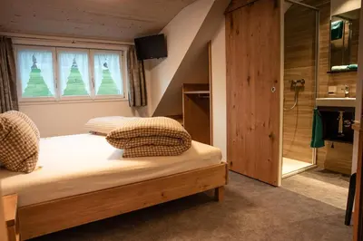 a bedroom with two beds and a shower at Hotel Landgasthaus Neues Bild, Eggerstanden in Appenzell