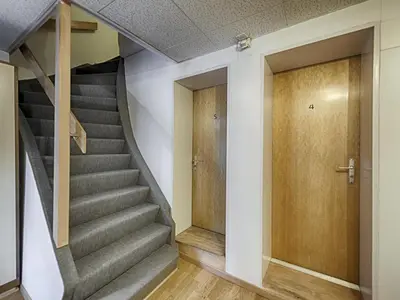 a staircase in a house with a wooden door at Hotel Weisses Kreuz in St. Gallen