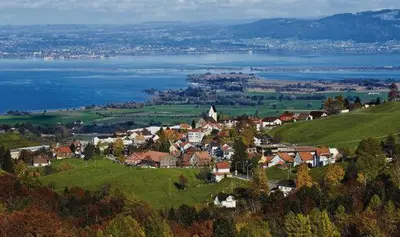 a small town on a hill next to a body of water at Haus Basilea in Wolfhalden