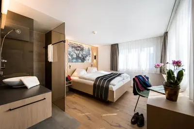 a bedroom with a bed and a laptop on a desk at Hotel Restaurant Krone in Urnäsch