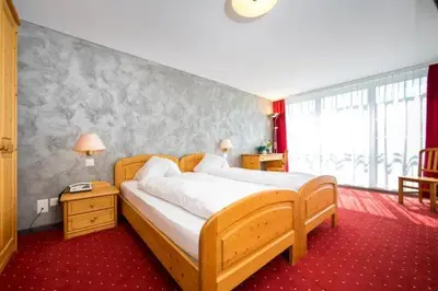 a bedroom with a large bed and a window at Hotel Restaurant Krone in Urnäsch