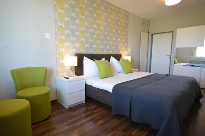 a bedroom with a bed and a chair and a bed sidx sidx sidx at Hotel Bodensee-Arena in Kreuzlingen