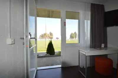 a room with a door and a desk and a window at Hotel Bodensee-Arena in Kreuzlingen
