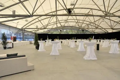 a large room with white tables and white chairs at Hotel Bodensee-Arena in Kreuzlingen