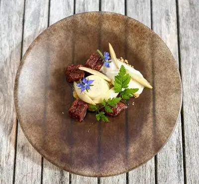 a plate with some food on a wooden table at Schloss Wartegg in Rorschacherberg