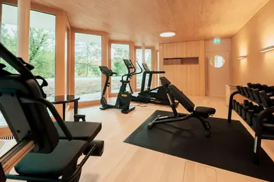 a gym with several treadmills and elliptical machines at Hof Weissbad Health & Wellness Resort in Weissbad