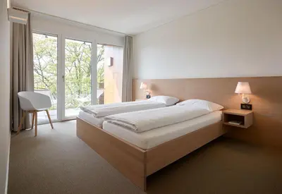 a bedroom with a large bed and a large window at APPADU Appartements in St. Gallen