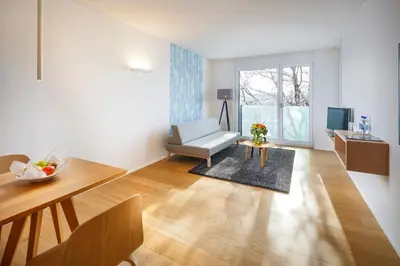 a living room with a chair and a table at APPADU Appartements in St. Gallen