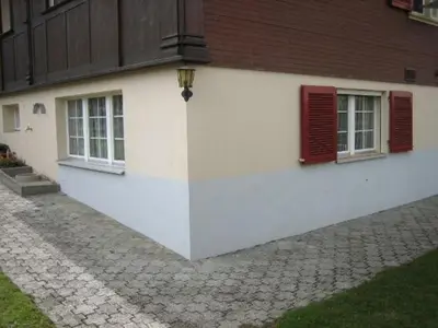 a white building with red windows and a cobblestone street at Ferienwohnung Inauen in Appenzell