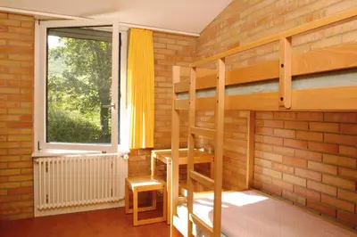 a room with two bunk beds and a window at St. Gallen Youth Hostel in St. Gallen