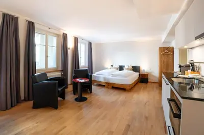 a hotel room with a bed and a kitchen at Hotel Le Lion - Self Check-in in Bischofszell