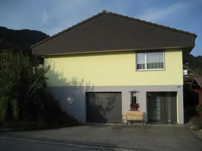 a yellow house with a bench in front of it at Studio-Ferienwohnung Hans Fässler in Appenzell