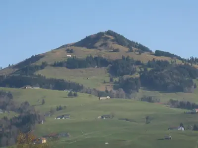 a green hill with houses on a green field at Studio-Ferienwohnung Hans Fässler in Appenzell