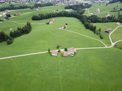 an aerial view of a green field with houses at Ferienstudio Familie Fässler-Dörig in Appenzell