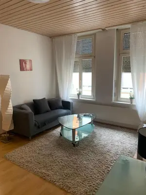 a living room with a couch and a glass table at room service Joppich in St. Gallen