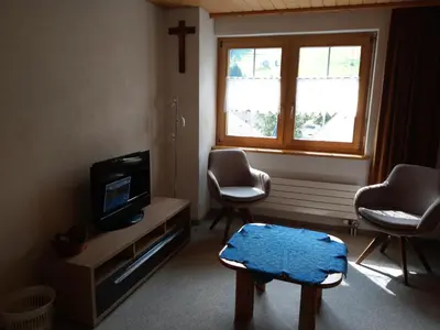 a living room with a tv and two chairs and a window at Gasthaus Schäfli in Alt Sankt Johann