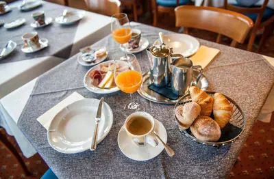 a table with a breakfast of croissants and orange juice at Schwendi Lodge in Unterwasser