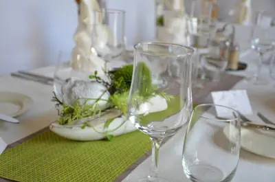 a table with glasses and a bowl of greens on it at Hotel Buchserhof in Buchs