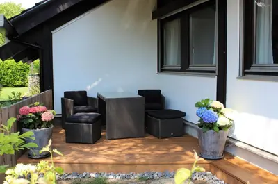a patio with chairs and a table and flowers at Studio zum Wohlfühlen in Kreuzlingen