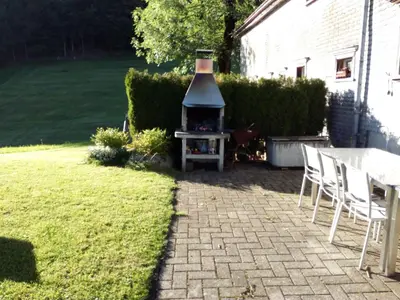 a backyard with a grill and a table and chairs at Ferienhaus Brand in Gais