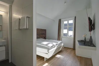 a white bedroom with a bed and a window at Gasthof Eisenbahn in Weinfelden