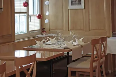 a dining room with a table with chairs and wine glasses at Gasthof Eisenbahn in Weinfelden