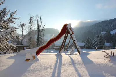 a slide in the snow with the sun in the background at Landgasthof Sternen in Bühler