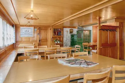 a dining room with wooden tables and chairs at Loosmühle in Weissbad