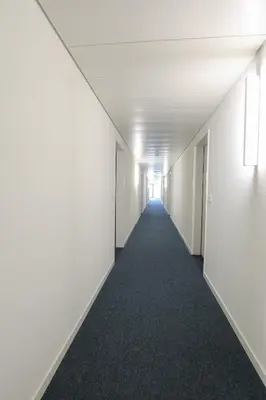 an empty corridor in an office building with a hallway at Uze Apartments in Uzwil SG in Uzwil
