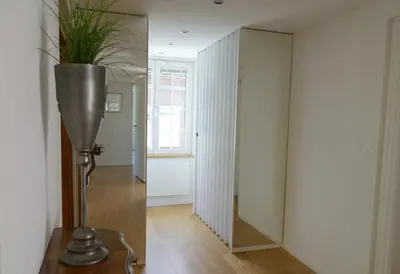 a hallway with a mirror and a vase with a plant at Haus zur Rose, St.Gallen, Bodensee, Säntis in Speicher