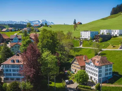 an aerial view of a village with houses and green hills at Haus zur Rose, St.Gallen, Bodensee, Säntis in Speicher