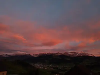 a sunset over a city with mountains in the background at Gasthaus Bären Schlatt in Appenzell