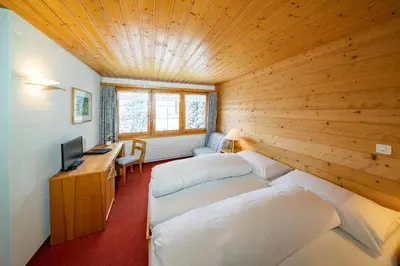 two beds in a room with a wooden ceiling at Hotel und Restaurant Chäseren in Schönengrund