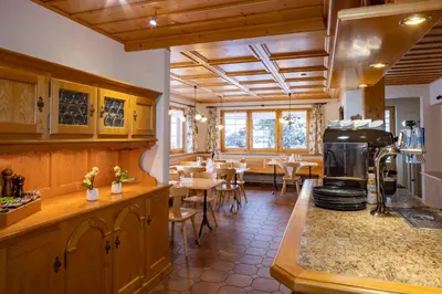a kitchen with a counter and a dining room with tables at Hotel und Restaurant Chäseren in Schönengrund