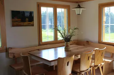 a dining room with a wooden table and chairs at Chalet Nueschwendi in Ebnat
