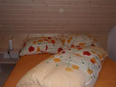 a bed with a floral comforter and two pillows at Ferienwohnung Brülisauer in Brülisau