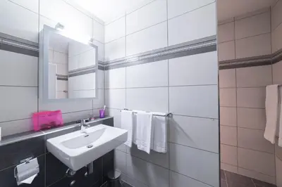 a white bathroom with a sink and a mirror at Sunnewies in Wildhaus