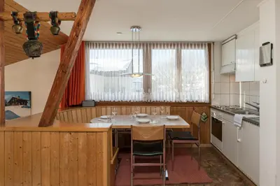 a kitchen with a table and chairs in a room at Chalet Pfiff in Wildhaus