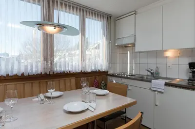 a kitchen with a table with wine glasses on it at Chalet Pfiff in Wildhaus