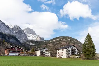 a village in a field with mountains in the background at Schwalbennest in Wildhaus